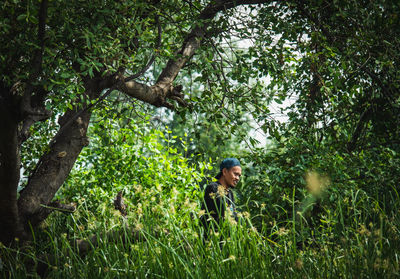 Rear view of woman standing in forest