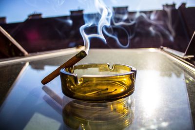 Close-up of cigar in ashtray on table