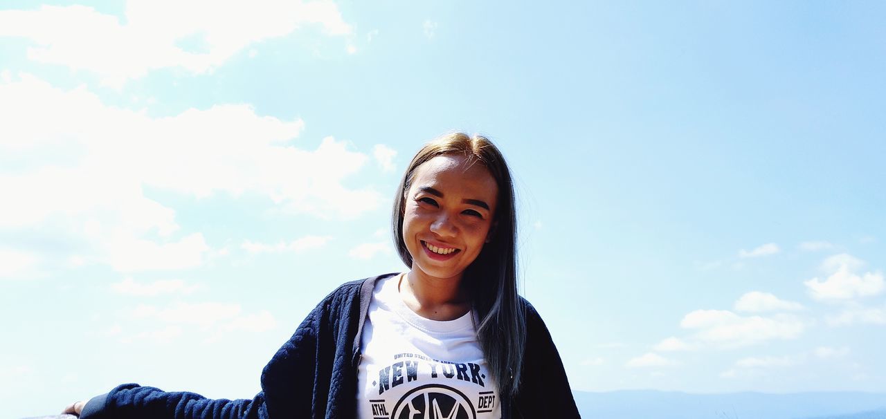 sky, portrait, smiling, one person, happiness, front view, young adult, lifestyles, real people, cloud - sky, young women, looking at camera, day, leisure activity, headshot, nature, toothy smile, teeth, emotion, outdoors, beautiful woman, teenager, hairstyle