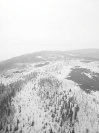 Scenic view of snow covered land against sky