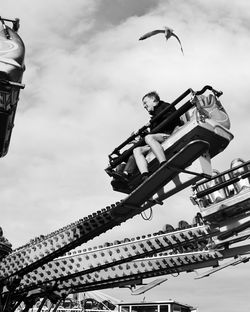 Low angle view of man on building against sky