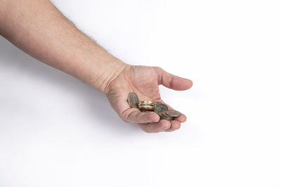 Close-up of hand holding cigarette against white background