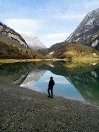 High angle view of person standing by lake against mountains 