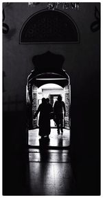 Rear view of silhouette people walking in corridor