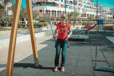 Full length of young woman sitting on the swing