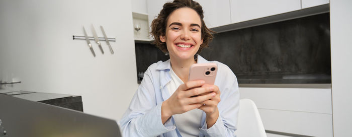 Portrait of young woman using phone