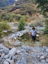 Full length of young man hiking near a creek.