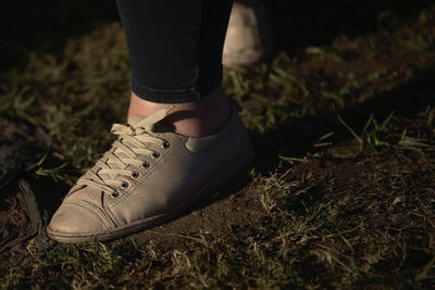 Low section of person wearing shoes on land