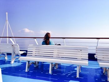 Low angle view of woman sitting on a bench on a boat