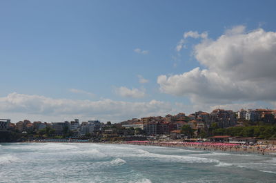 Panoramic shot of sea and buildings against sky