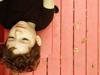 Portrait of happy boy standing against door
