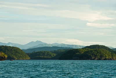 Scenic view of sea and mountains against sky