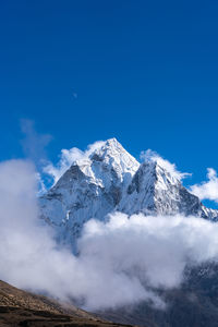 Scenic view of snowcapped mountains against blue sky