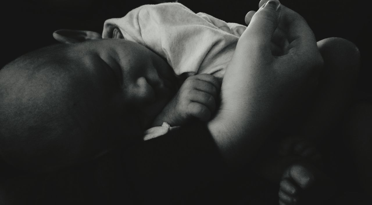 CLOSE-UP OF BABY LYING ON HAND