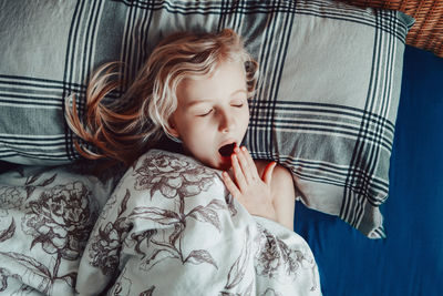 Child girl sleeping yawning in bed at home. sweet dreams. everyday routine in the morning. 