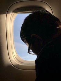 Portrait of man looking through airplane window