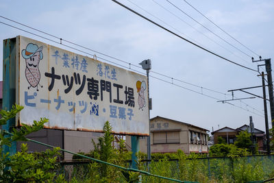 Low angle view of information sign against sky