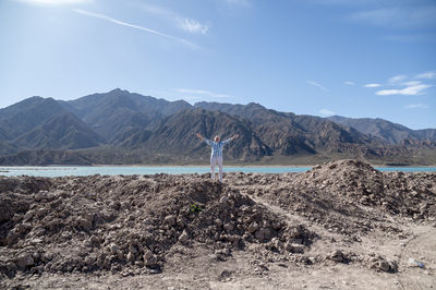 Man with open arms while enjoying the nature in a mountain landscape.