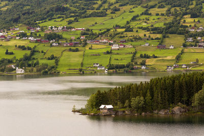 Scenic view of green landscape and houses against sky