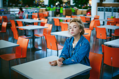 Portrait of woman sitting on chair at supermarket