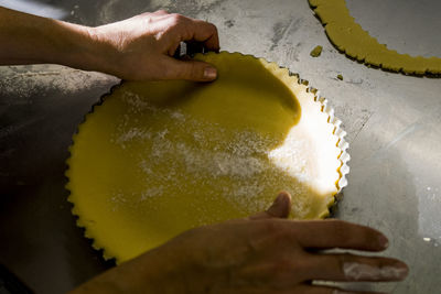 Pastry chef is posing the dough in cake oven pan of a cake laboratory
