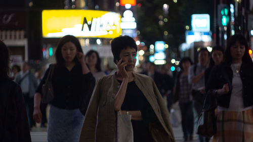 People standing on street in city at night