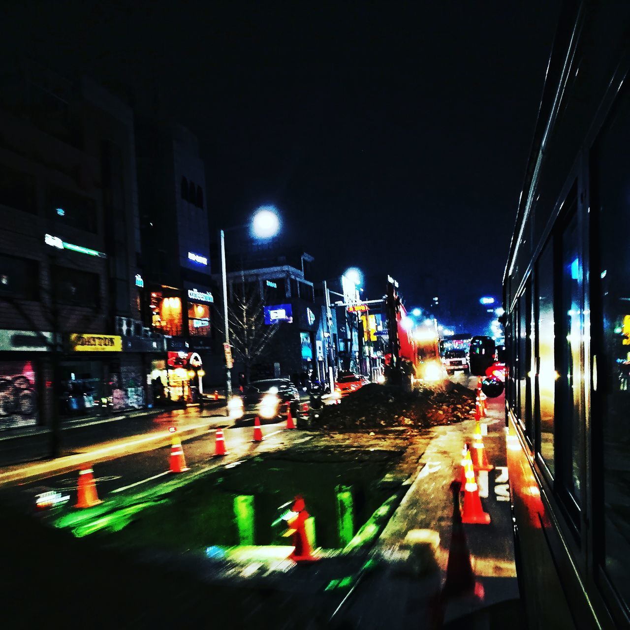 CARS ON ILLUMINATED ROAD AGAINST SKY AT NIGHT