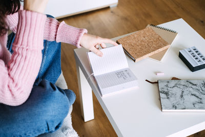 Midsection of woman using laptop on table