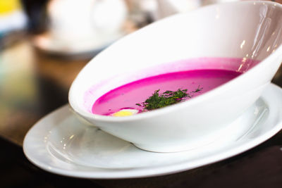 Close-up of pink rose in cup on table