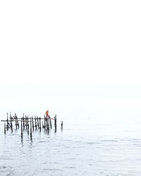 People in sea against clear sky