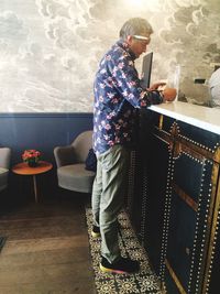 Rear view of man sitting on table at home