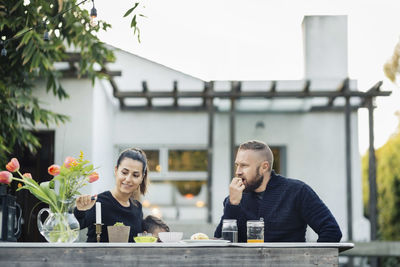 Man looking at woman lighting candle at yard