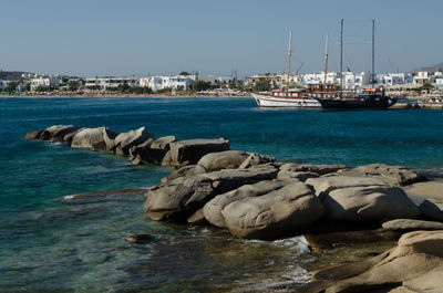 Sailboats on sea against clear sky