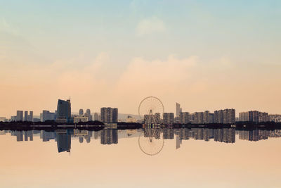 Reflection of buildings in river during sunset