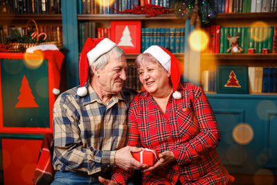 Elderly woman giving present to her beloved husband.