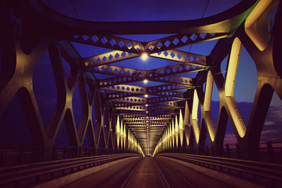Illuminated bridge against blue sky