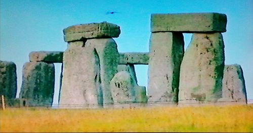 Low angle view of old ruins on field against sky