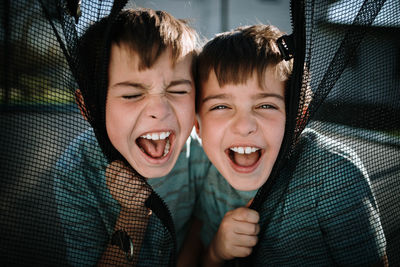 Portrait of laughing boys sitting outdoors