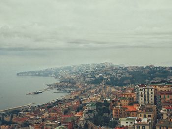 High angle view of townscape by sea against sky