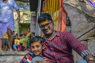 Portrait of father and son sitting outdoors