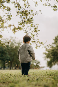 Rear view of boy standing in park