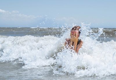 Close-up of woman covering face in sea