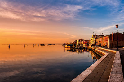 Pier by sea against sky during sunset