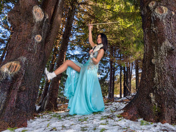 Woman playing on violin in the forest