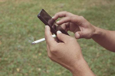 Close-up of hand holding cigarette