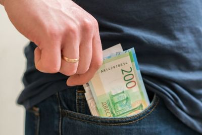 Midsection of man removing paper currencies from pocket