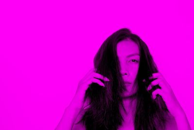 Portrait of a beautiful young woman over pink background