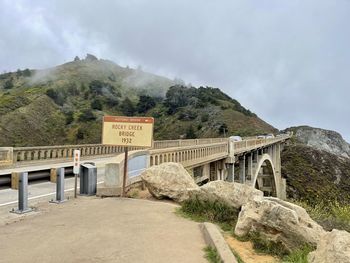 Bridge over mountain against sky