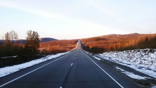 Empty road with mountains in background