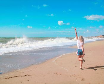 Full length of boy on beach against sky